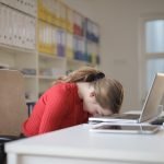 a sad woman with her head on a keyboard