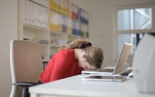 a sad woman with her head on a keyboard