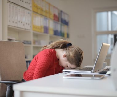 a sad woman with her head on a keyboard