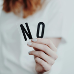 woman holding a sign that says no to set boundaries