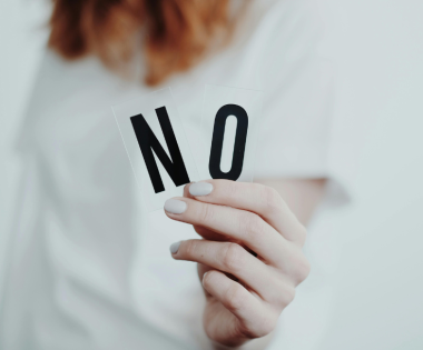 woman holding a sign that says no to set boundaries