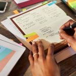 hands writing in a notebook - weekly planning for entrepreneurs