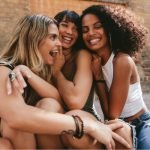 three women hugging and smiling - am I an introvert