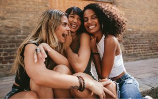 three women hugging and smiling - am I an introvert