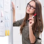Woman writing on strategy board - Visibility strategy for women