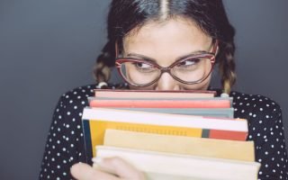 shy introvert woman hiding behind books